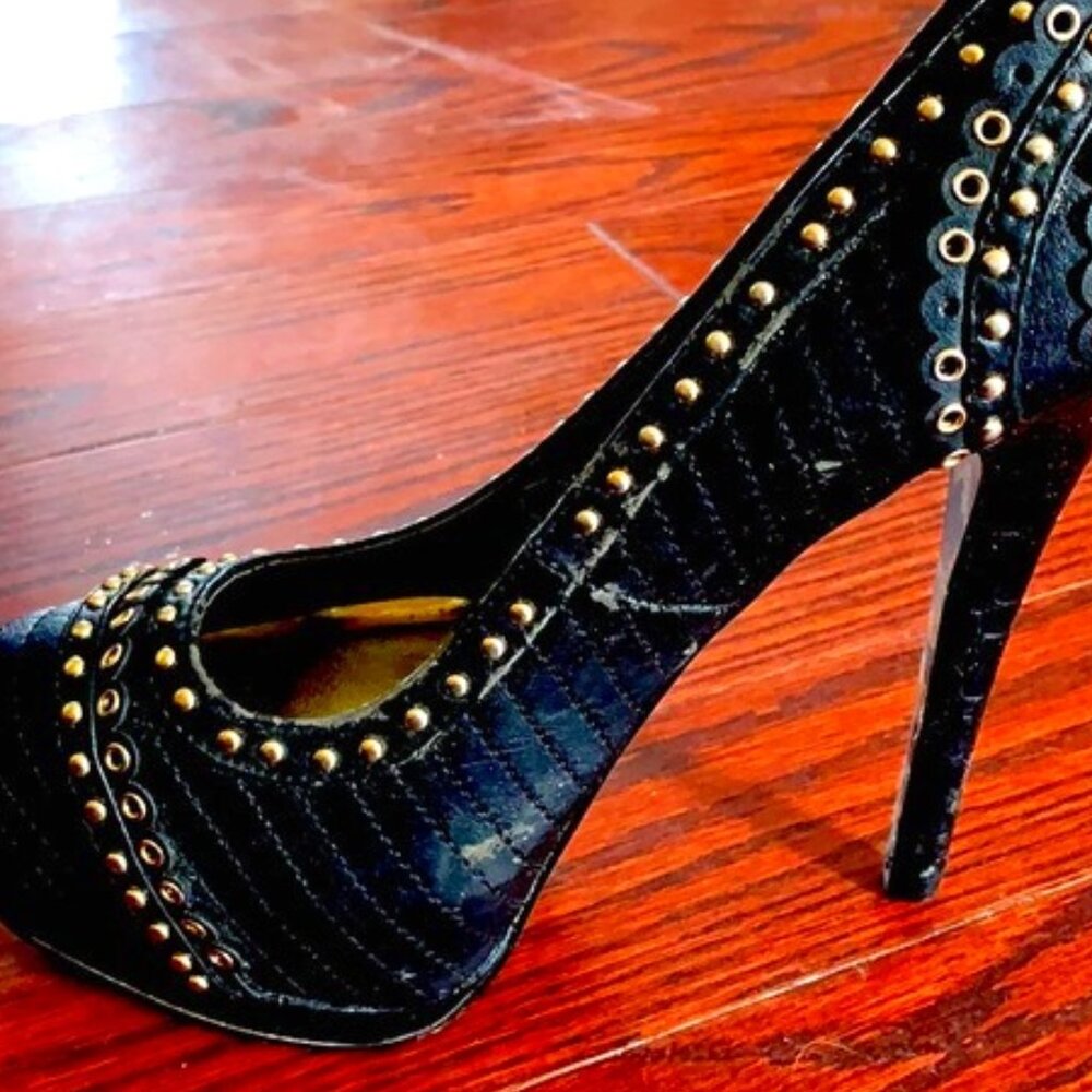 Very high black heels with gold detail.